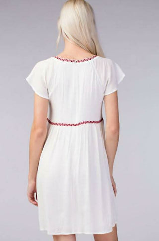 Back view of white short sleeve babydoll dress with relaxed fit