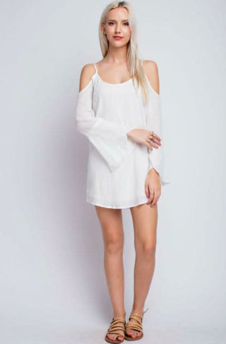 Model posing in the white bell sleeve cover-up dress.