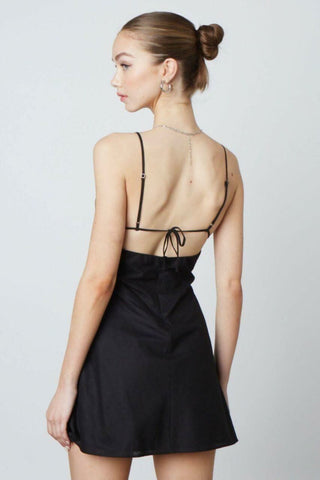 Back view of a black linen-blend mini dress showing the open back 