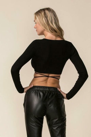 Back view of a black long sleeve crop top featuring a versatile tie-back closure