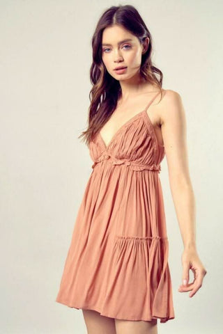 Model wearing earthy brown ruffle mini dress with adjustable straps