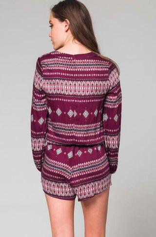 Back view of a casual long sleeve romper in a burgudy print 