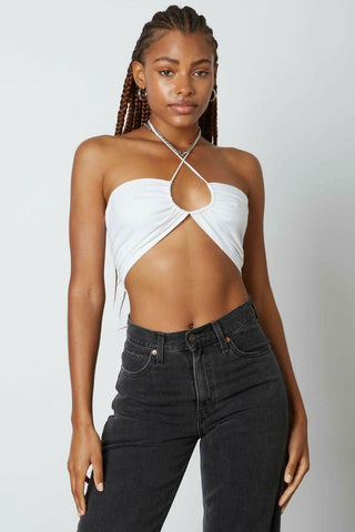 Woman wearing a white bandeau cross-front halter crop top with front keyhole 