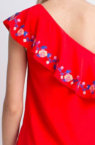 close-up of the pink and blue floral embroidery on the red ruffle neckline