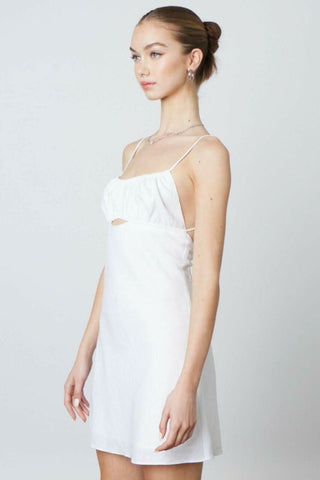 Side profile of the Luna white mini dress featuring a flattering A-line silhouette 