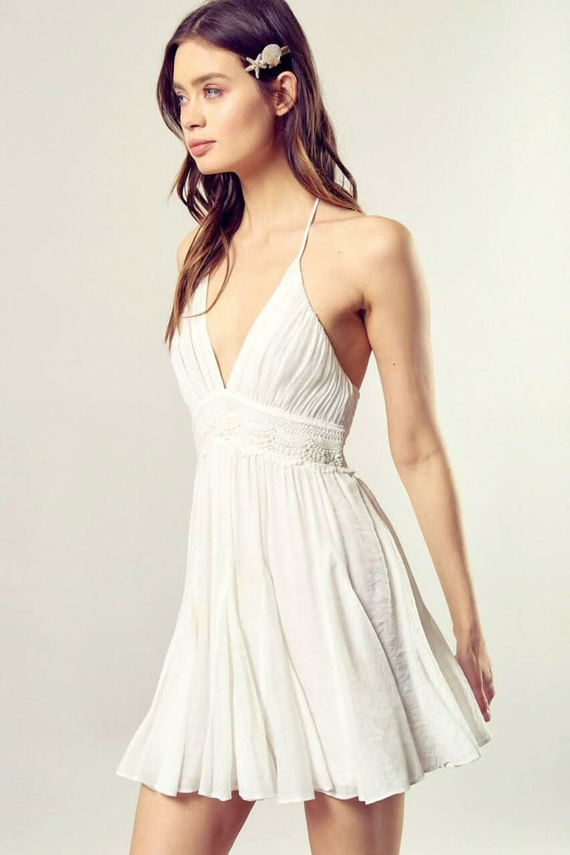 White halter mini dress with a lace insert at the waist and a flowy A-line skirt.
